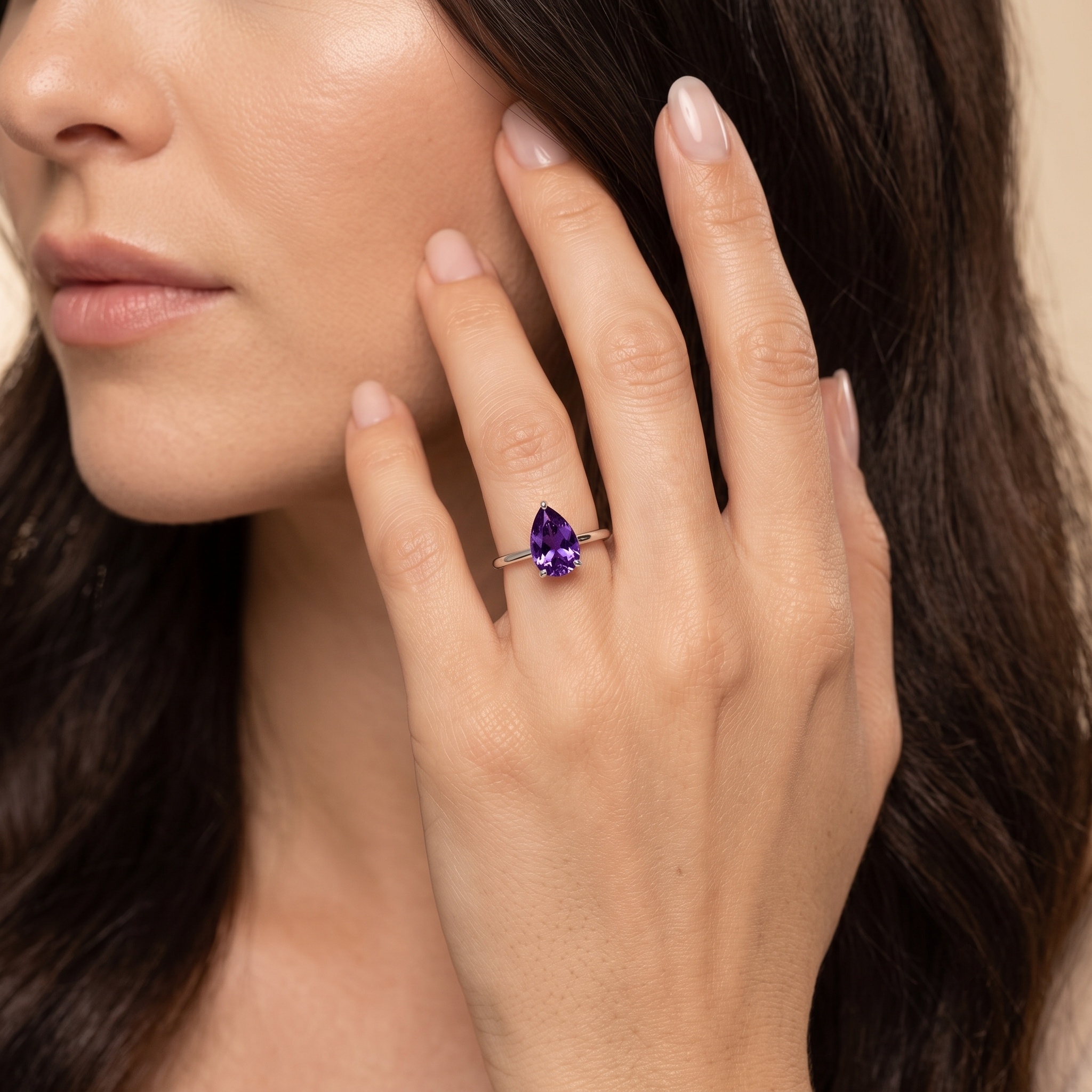 A model is wearing Pear Shape Purple Sapphire Cathedral Solitaire Ring in White Gold