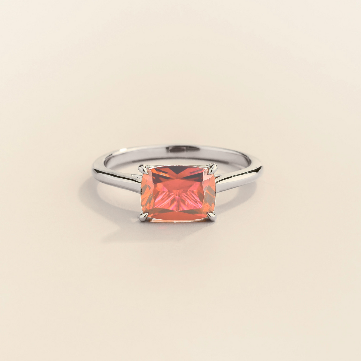 Kissen Ring in white gold, set with Padparadscha Sapphire in an east–west setting.
