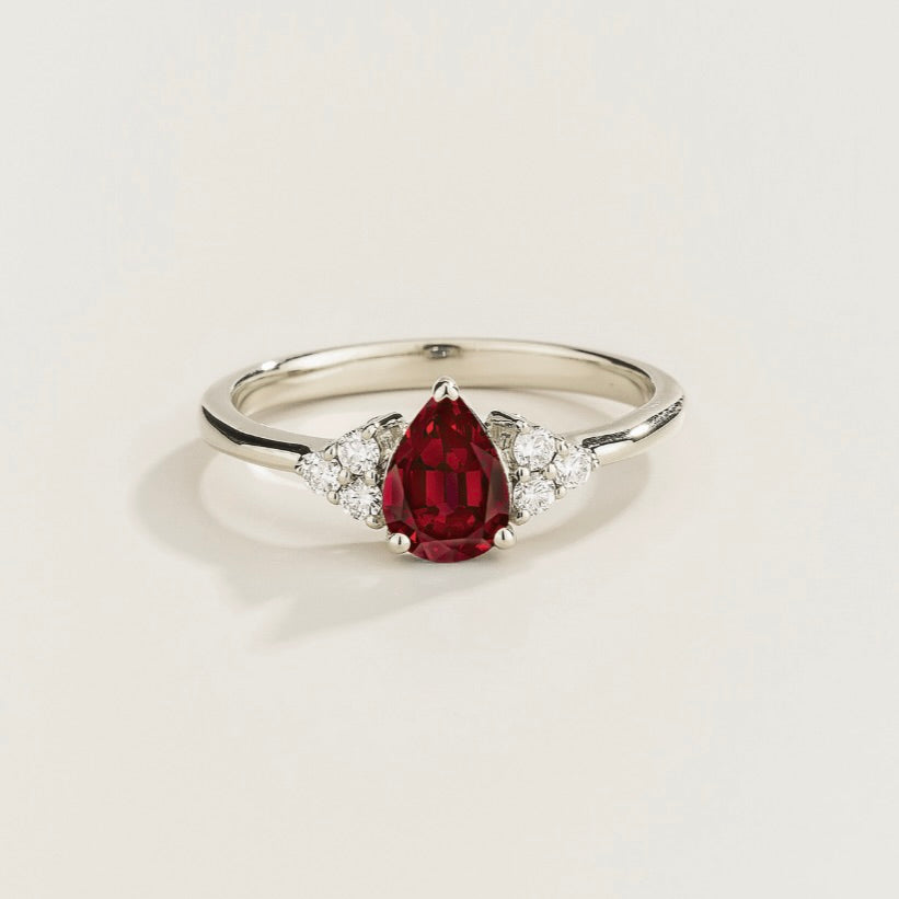 Juvetti white gold ring featuring a pear-cut lab-grown ruby with lab-grown diamond side stones.