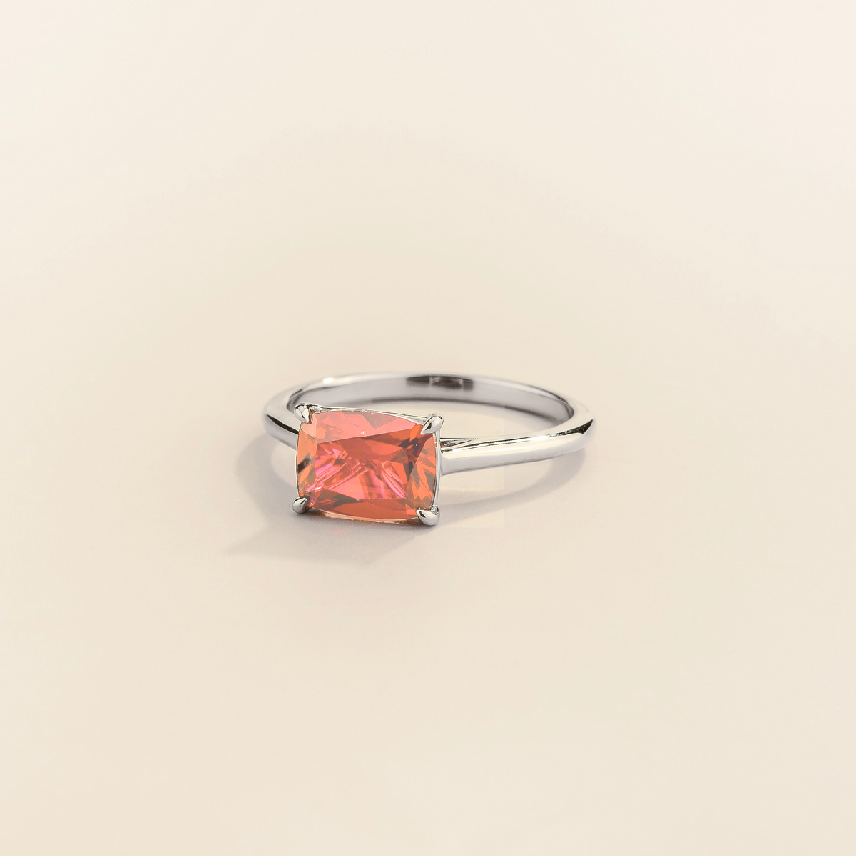 Kissen Ring in white gold, set with Padparadscha Sapphire in an east–west setting.