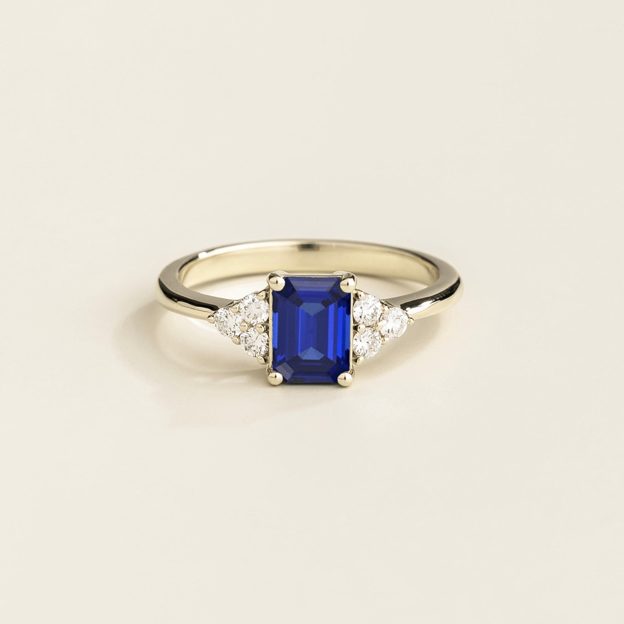 Juvetti white gold ring featuring an emerald-cut lab-grown royal blue sapphire with lab-grown diamond side stones.