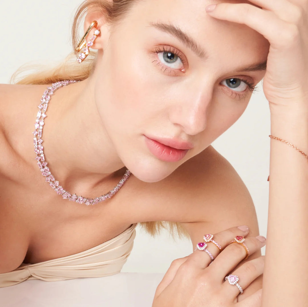 A beautiful model wearing Lago rosa necklace set with lab grown pink sapphire. Baguette, princess, drop pear and round gem stones.
