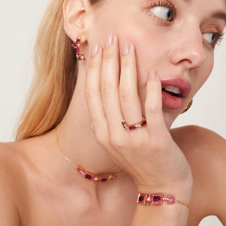 A model wearing Lanna earrings, Forma ring, Ciceris bracelet and necklace set with lab grown diamond and ruby gem stones by Juvetti London