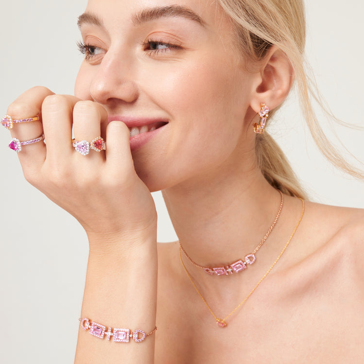 A model wearing Diana rings, Ciceris necklace and bracelet, Melba earrings and Lanna earrings set with lab grown diamond, pink sapphire and padparadscha gem stone