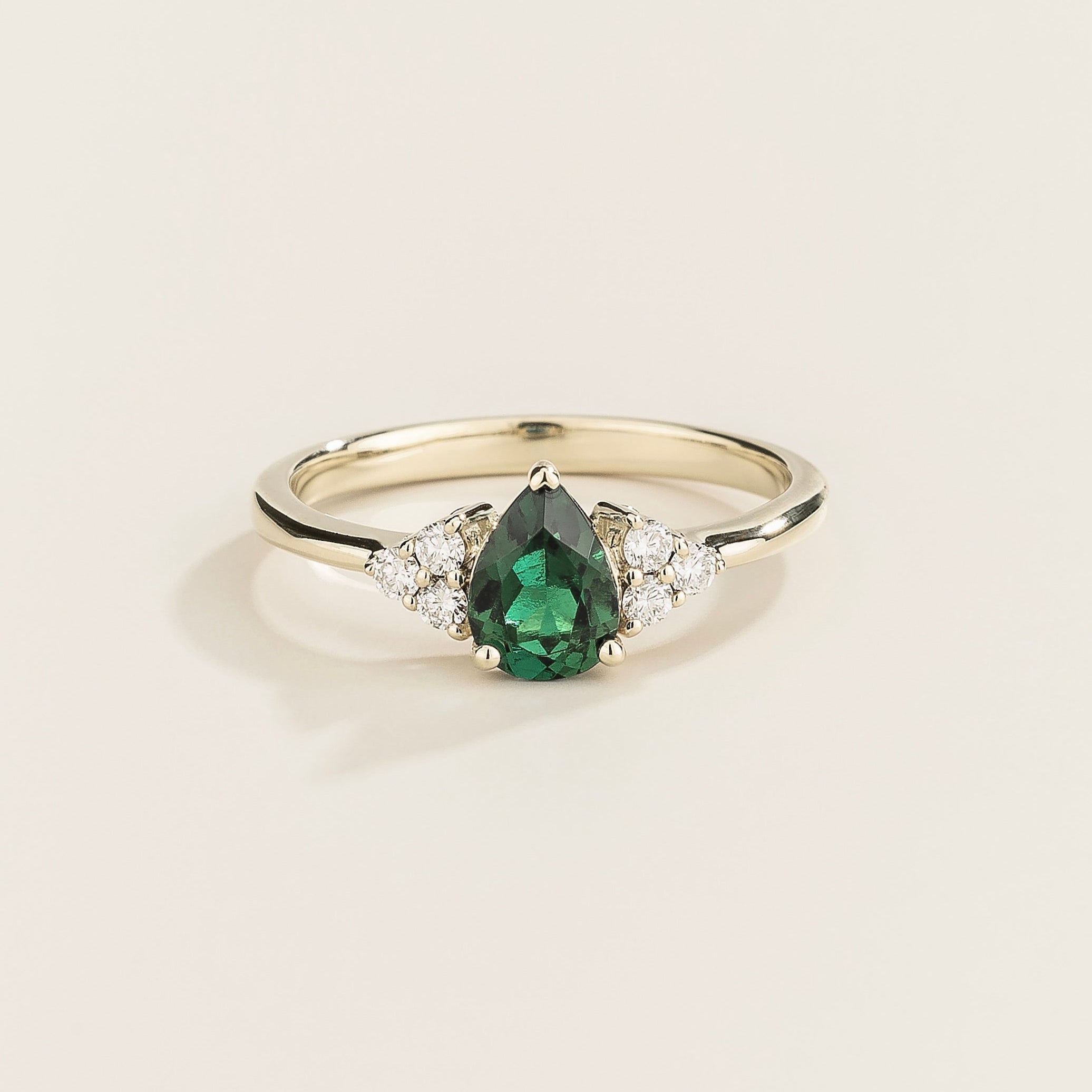 Juvetti white gold ring featuring a pear-cut lab-grown emerald with lab-grown diamond side stones.
