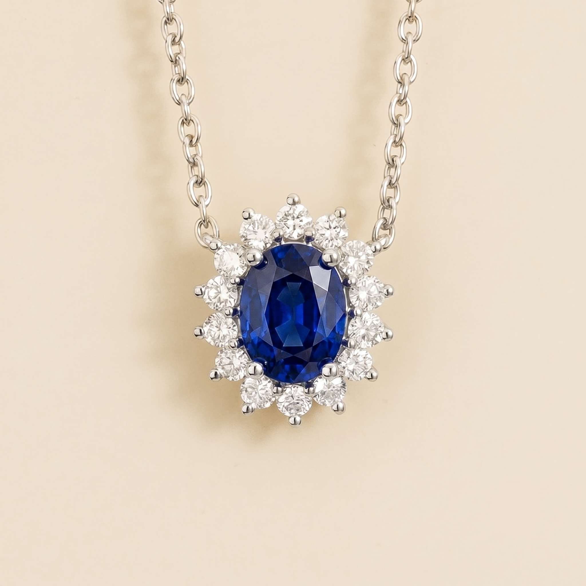 White Gold necklace from Juvetti called divo set in oval blue sapphire and diamond halo.