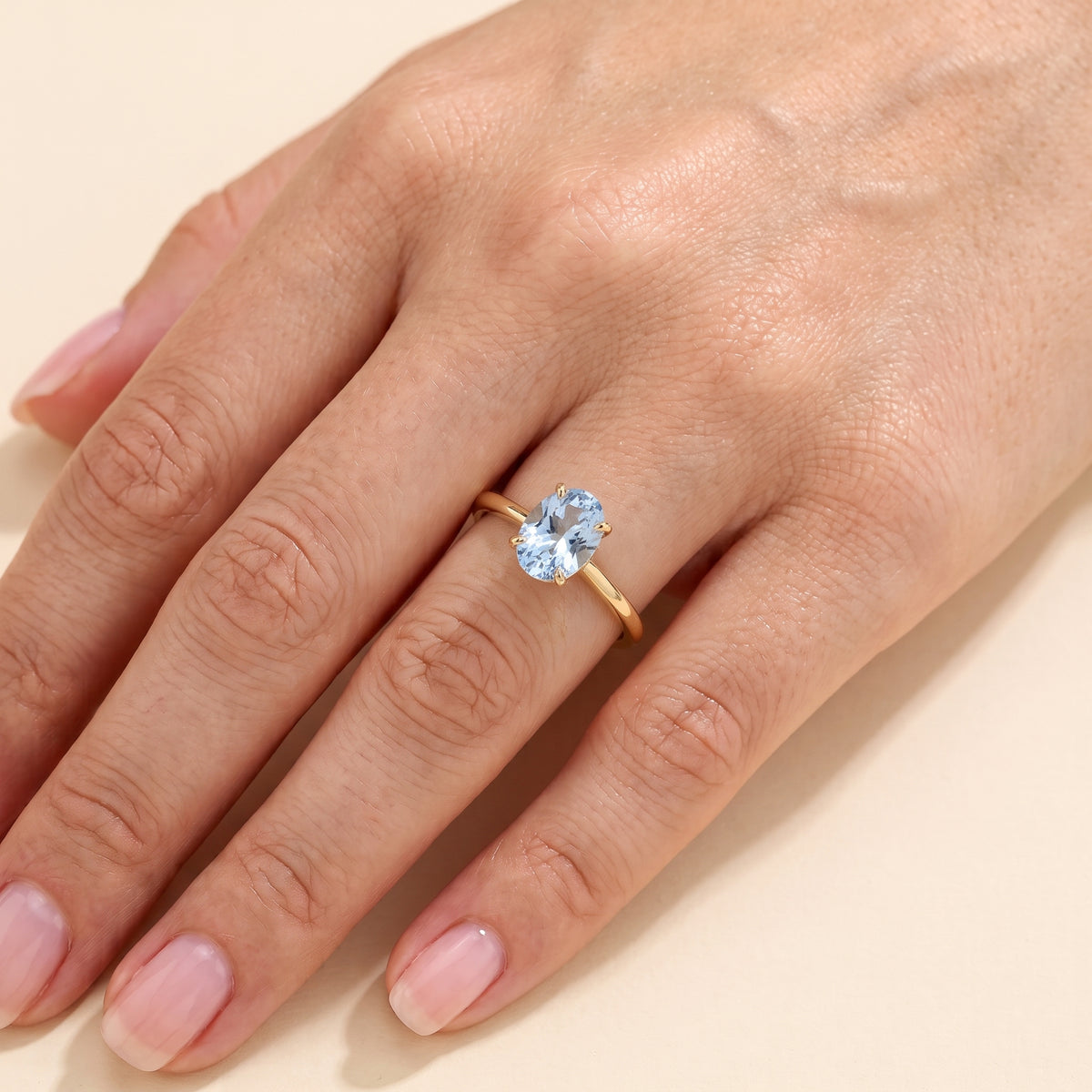 The model is wearing Lyra Oval Shape Aquamarine Cathedral Solitaire Ring in Gold