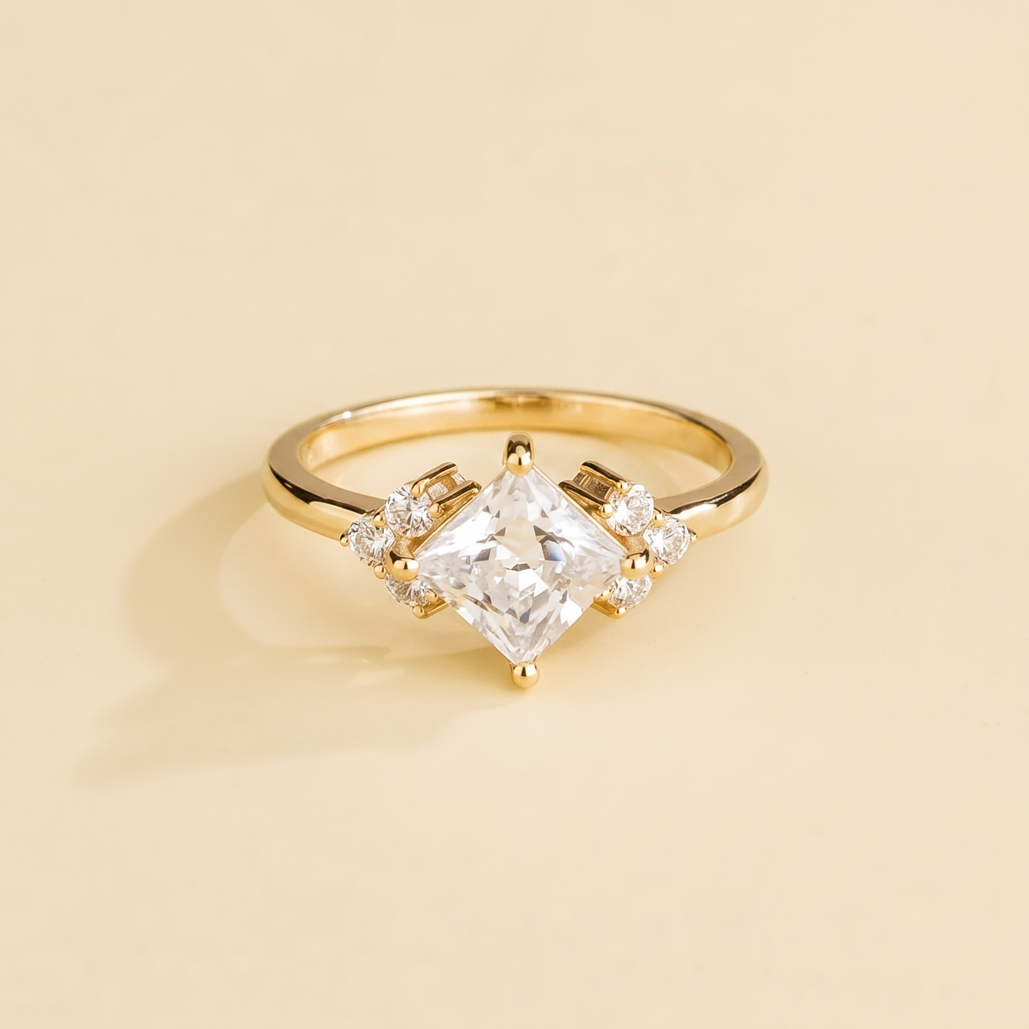 A gold ring with a central princess cut diamond and accent side diamonds set in a classic six-princess-cut style.