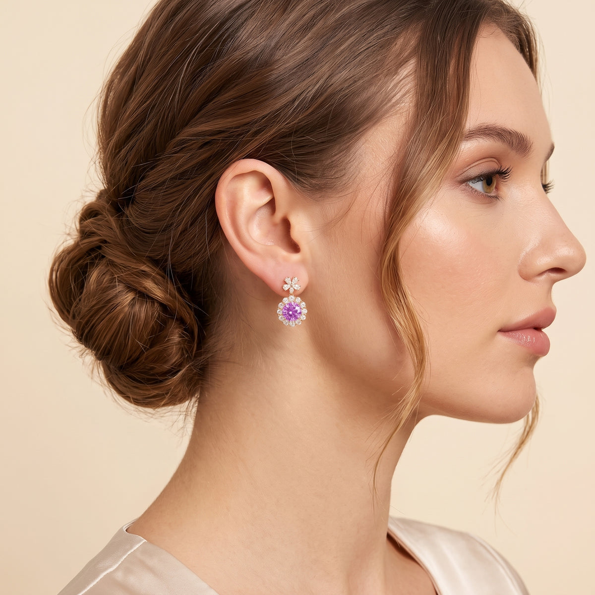 A model is wearing The Antoinette Round Purple Sapphire & Diamond Halo Pendant Earrings with Flower Bail