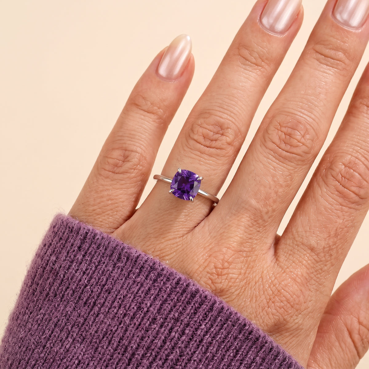 A model is wearing Iris Cushion Shape Purple Sapphire Cathedral Solitaire