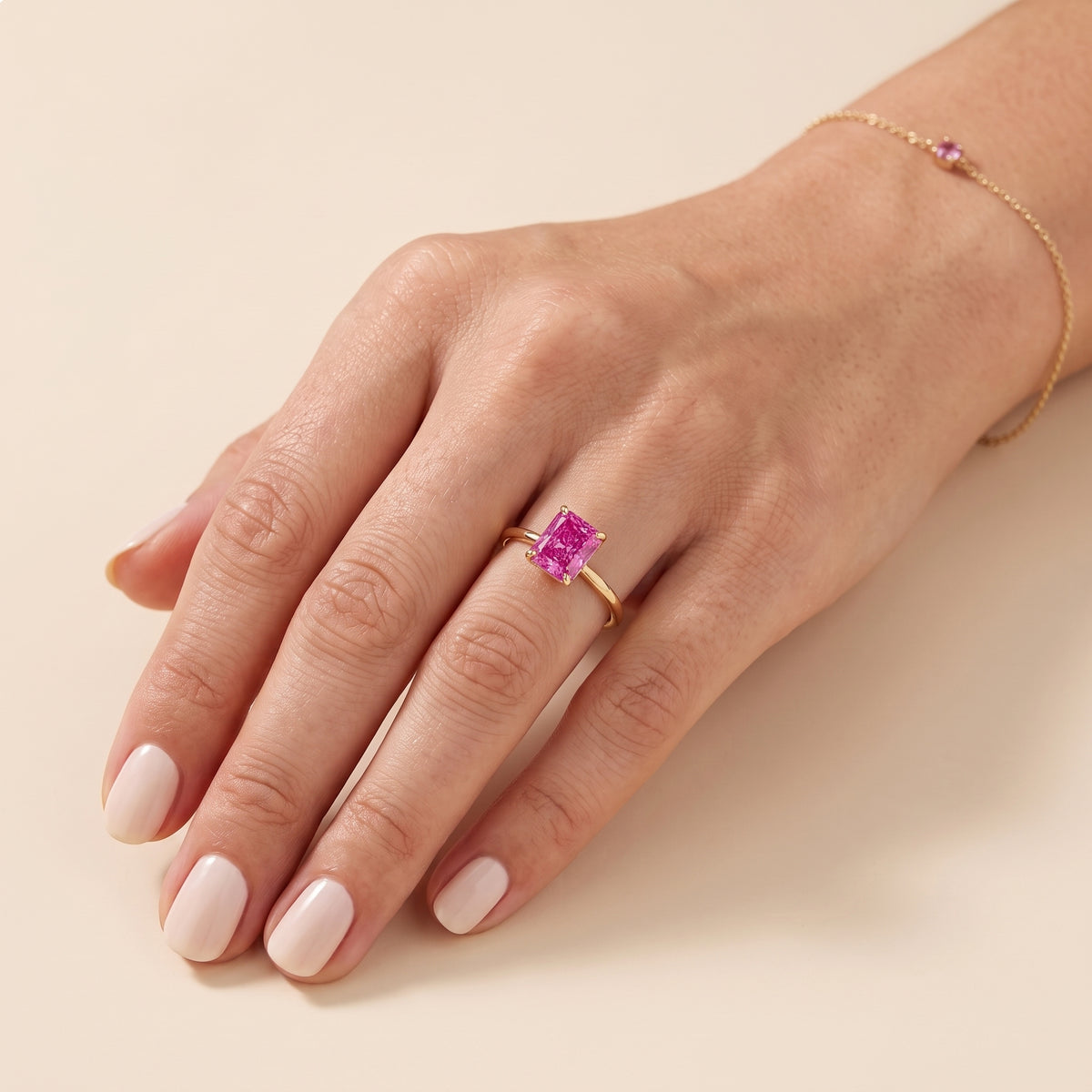 A model is wearing Clair Radiant Shape Vivid Pink Sapphire Cathedral Solitaire Ring