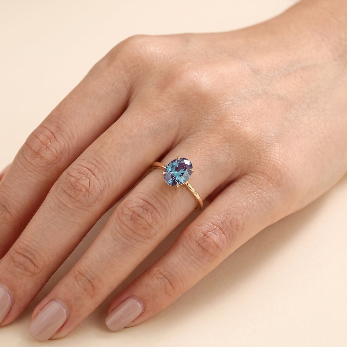 The model is wearing Lyra Oval Shape Alexandrite Cathedral Solitaire Ring in Gold