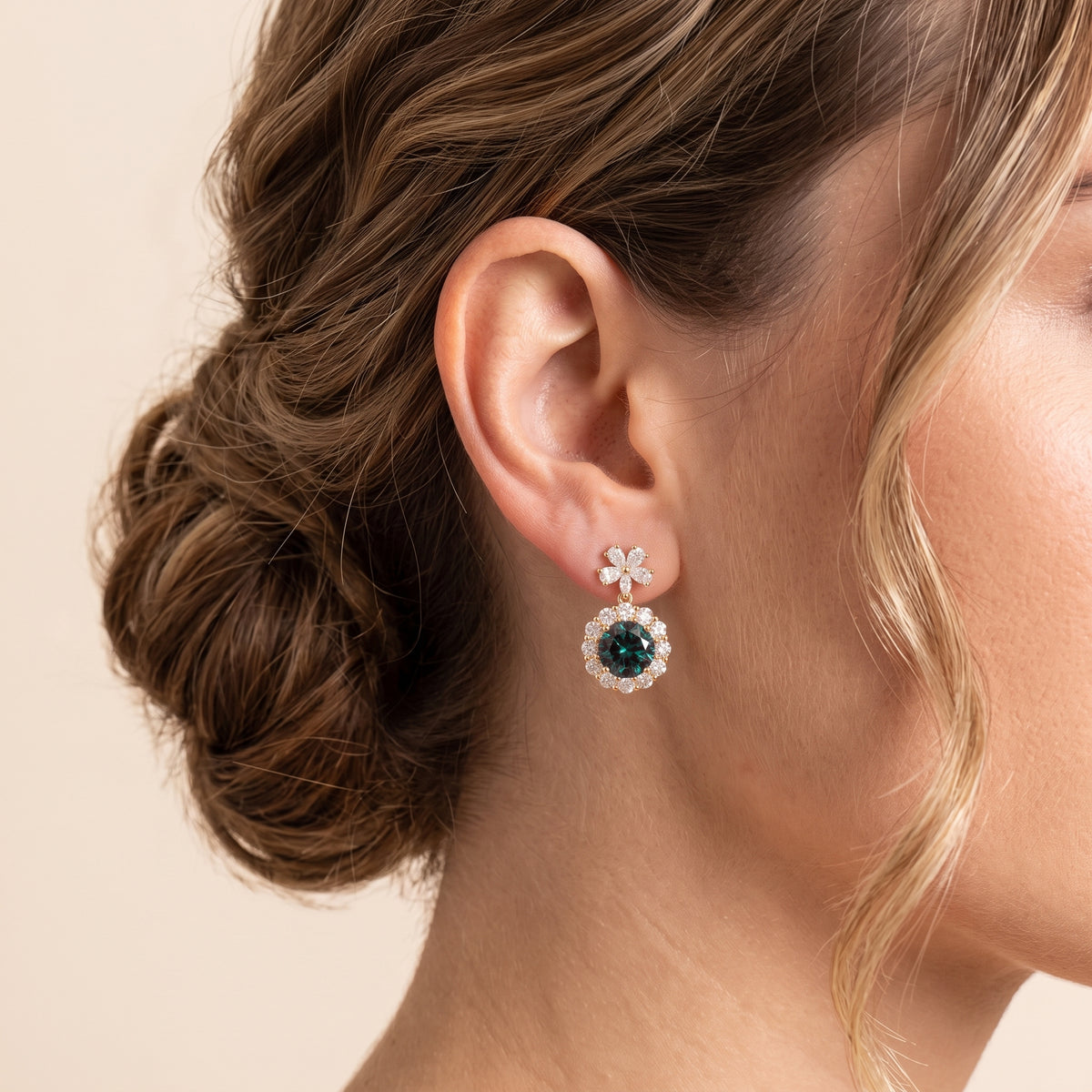 A model is wearing The Antoinette Round Alexandrite & Diamond Halo Pendant Earrings with Flower Bail