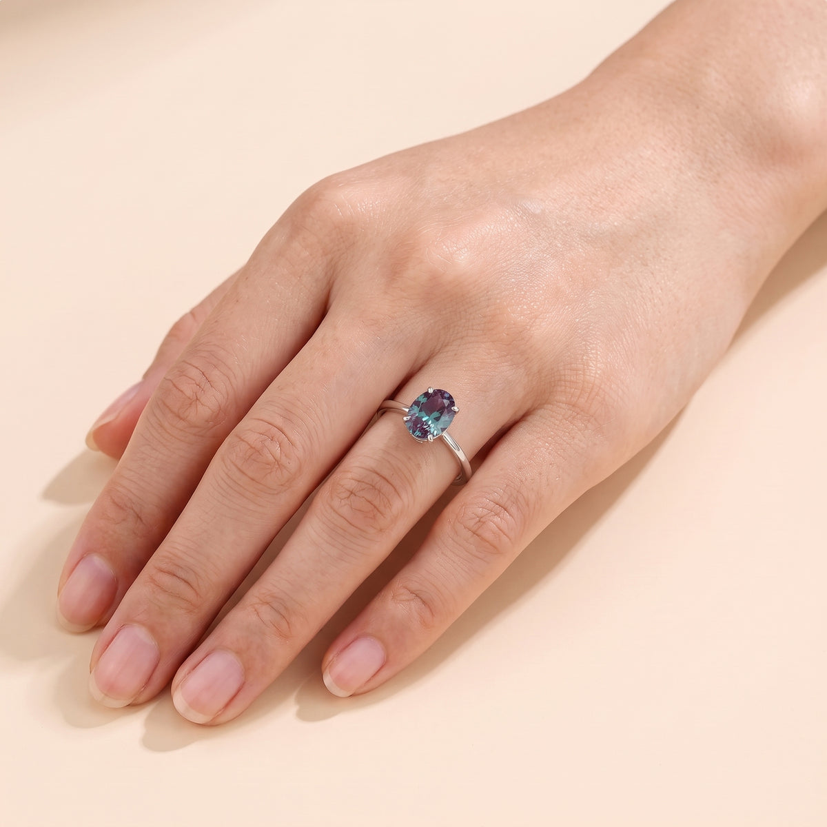 The model is wearing Lyra Oval Shape Alexandrite Cathedral Solitaire Ring in White Gold