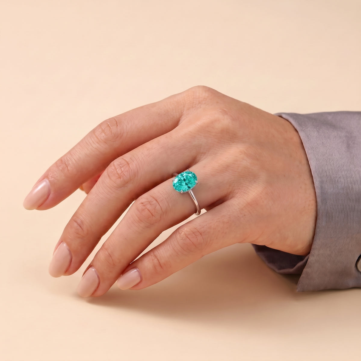 A model is wearing Lyra Oval Shape Paraiba Cathedral Solitaire Ring in White Gold
