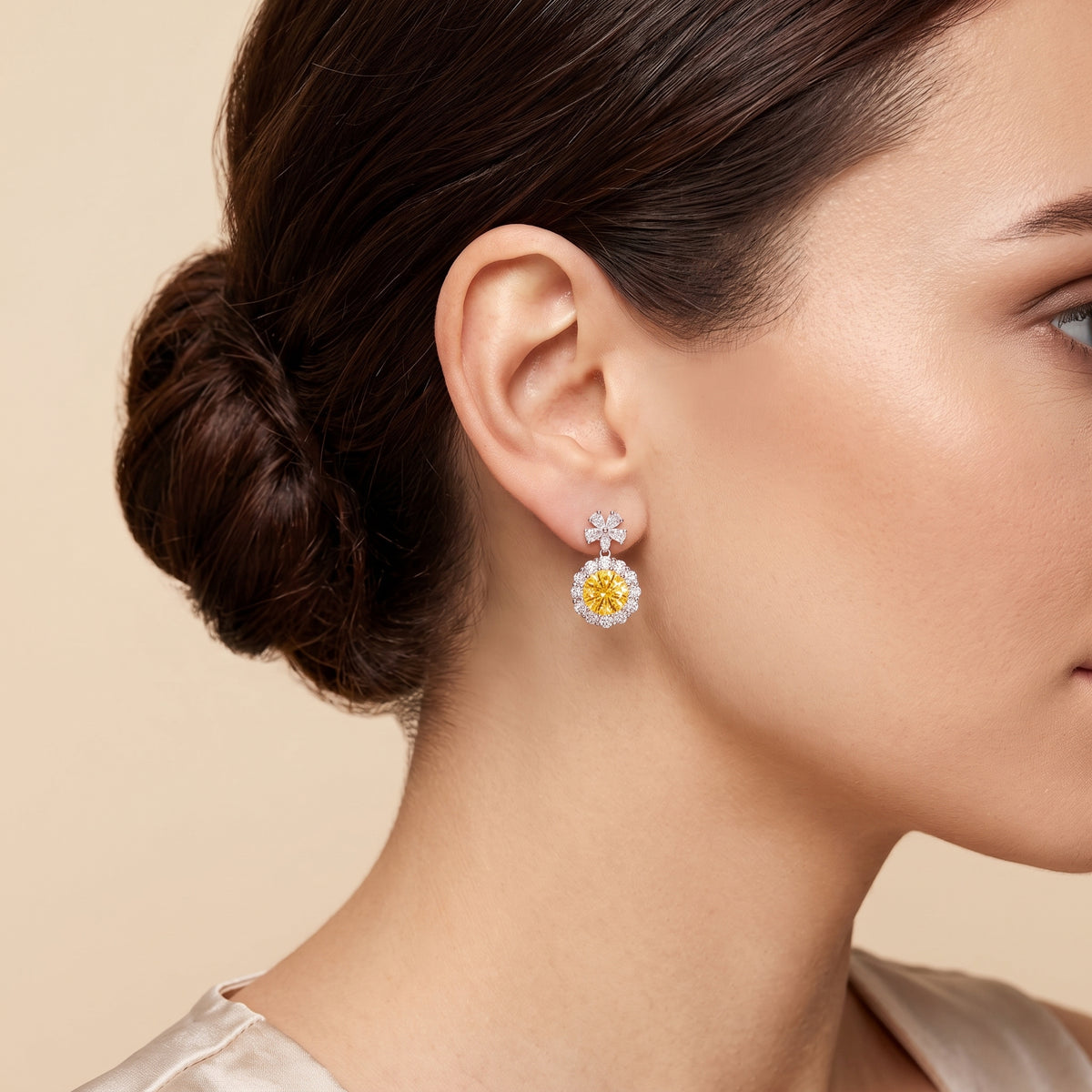 A model is wearing The Antoinette Round Yellow Sapphire & Diamond Halo Pendant Earrings with Flower Bail 