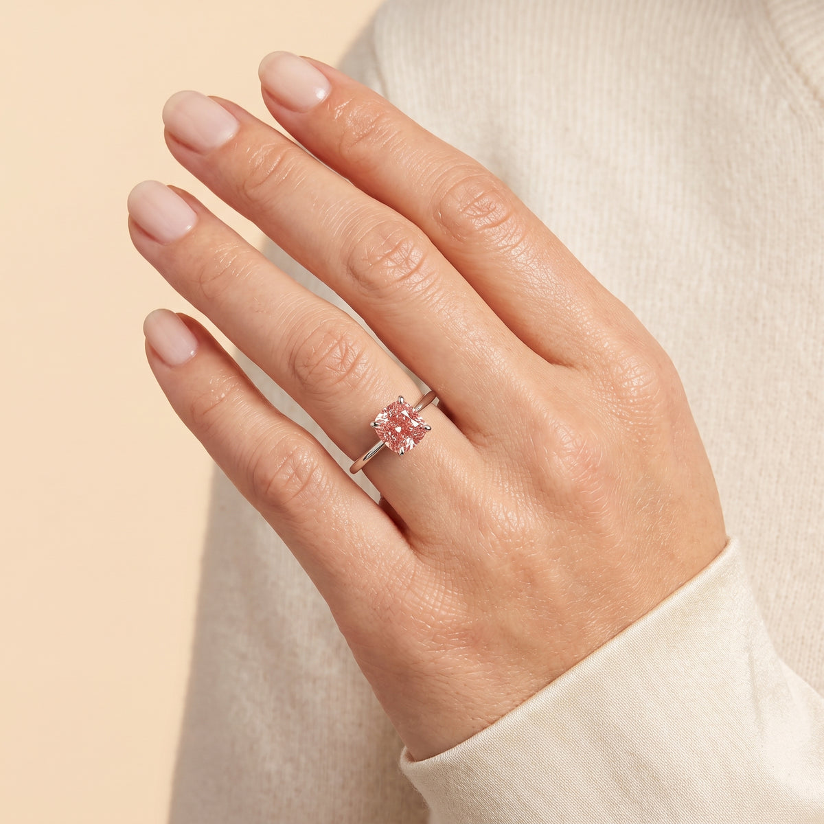 A model is wearing Iris Cushion Shape Padparadscha Sapphire Cathedral Solitaire