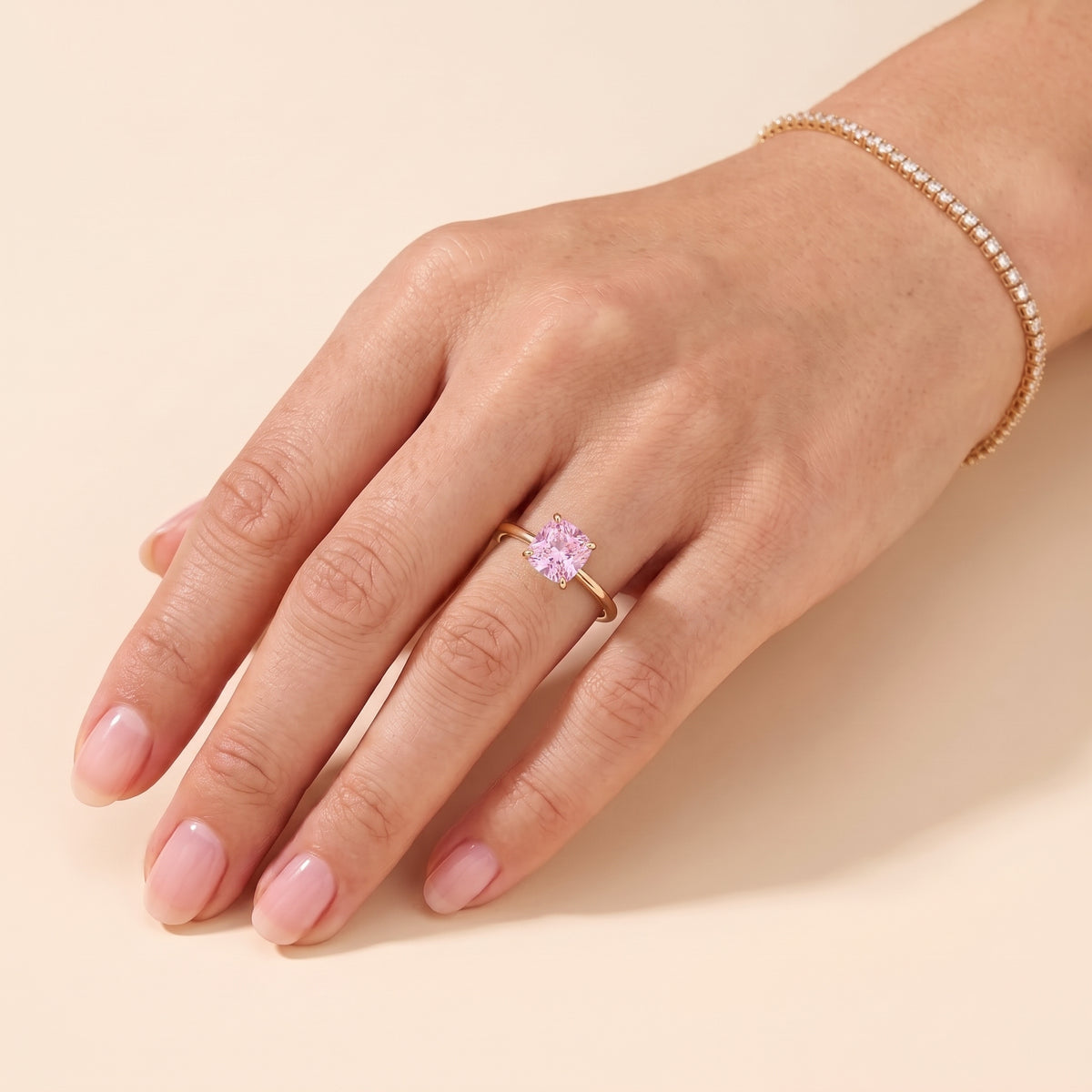 A model is wearing Iris Cushion Shape Pink Sapphire Cathedral Solitaire