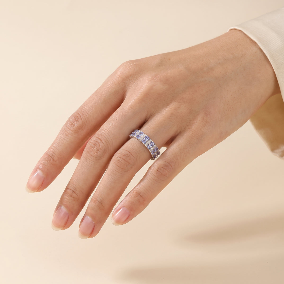 A model is wearing Tina Round Blue Sapphire and Diamond Eternity Ring in White Gold