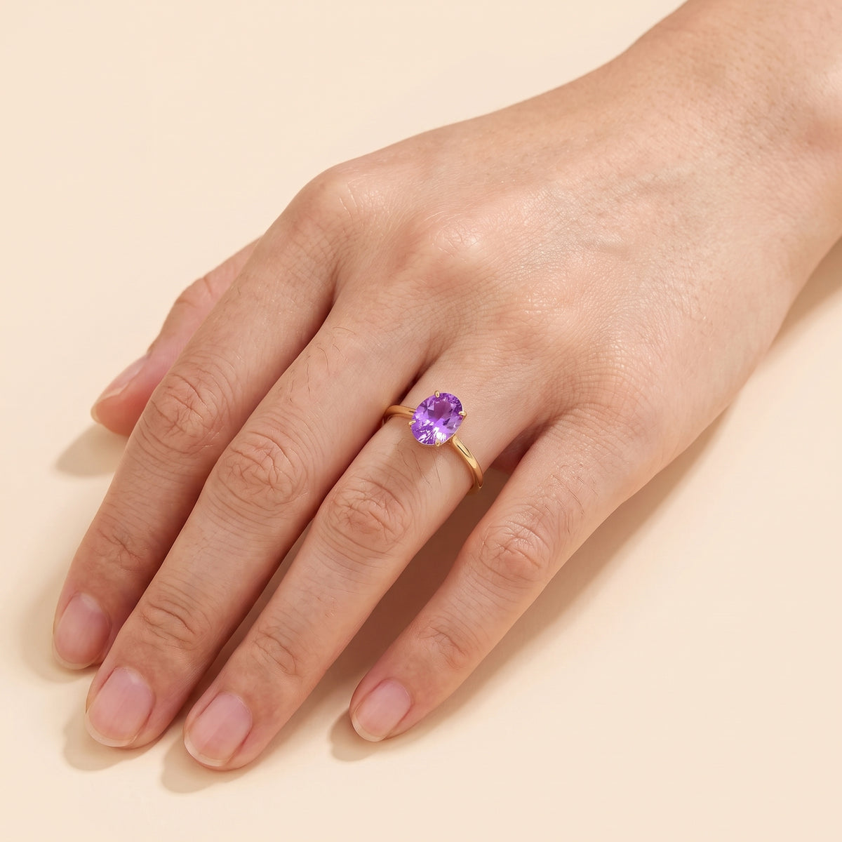 A model is wearing Lyra Oval Shape Purple Sapphire Cathedral Solitaire Ring in Gold