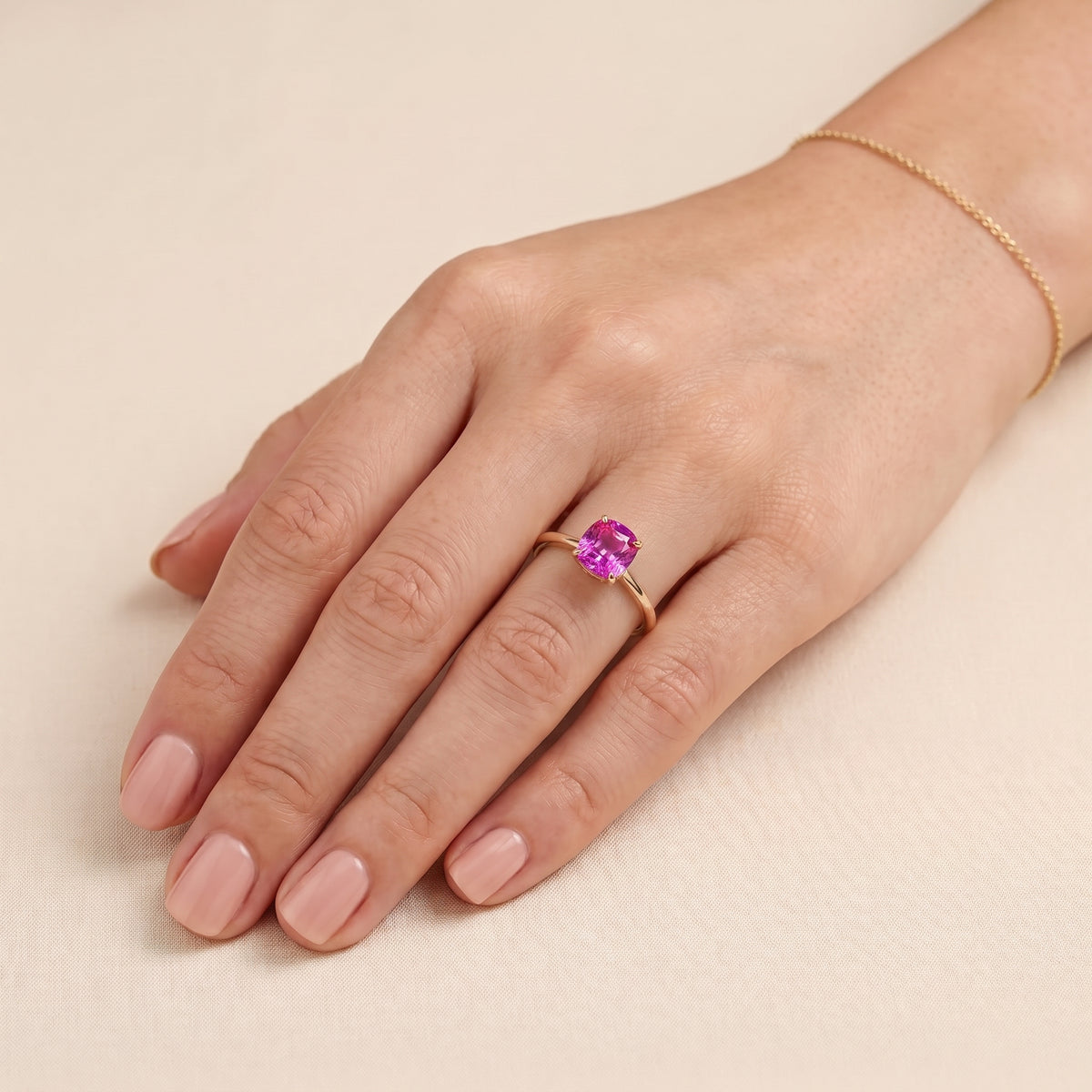 A model is wearing Iris Cushion Shape Vivid Pink Sapphire Cathedral Solitaire