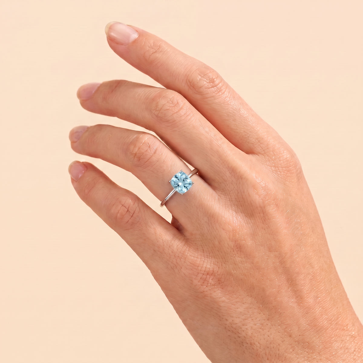 A model is wearing Iris Cushion Shape Aquamarine Cathedral Solitaire