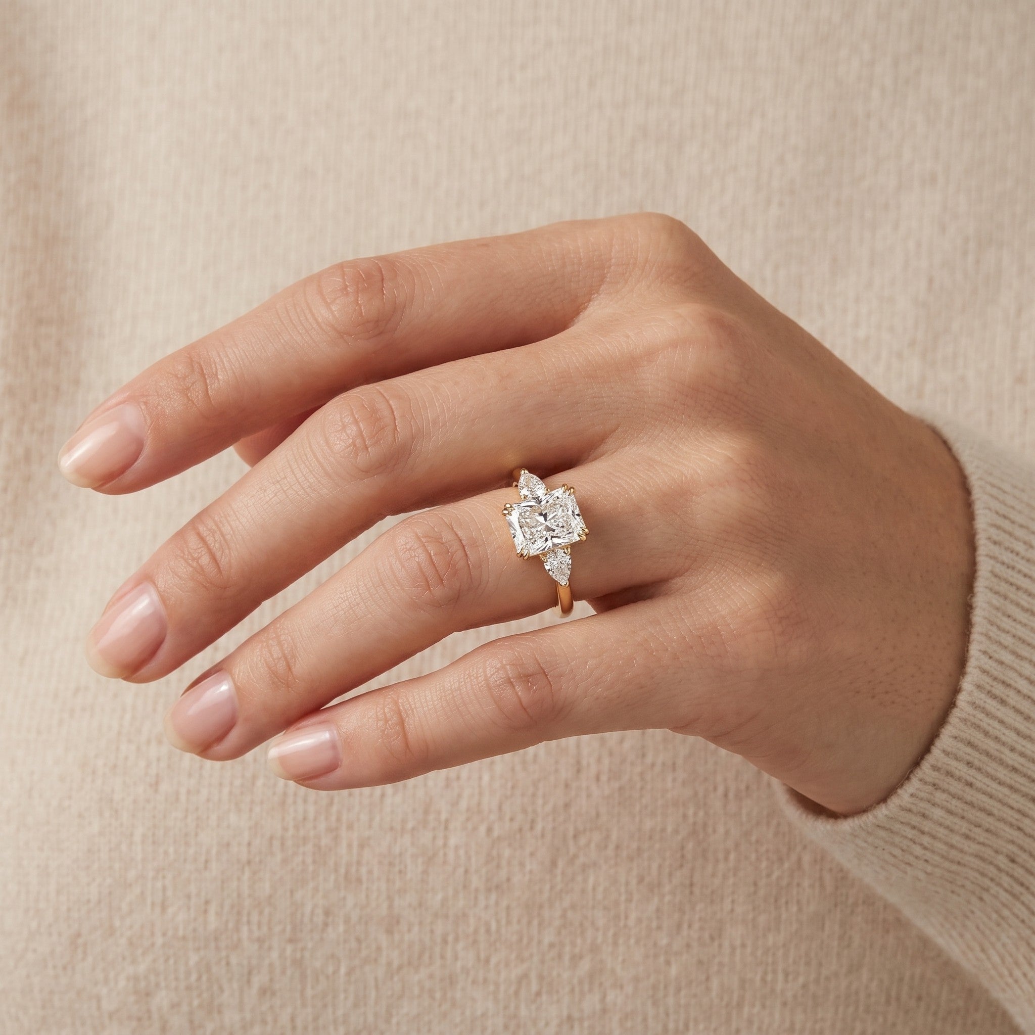 The model is wearing Bale Diamond Radiant Cut & Pear Cut Gold Ring