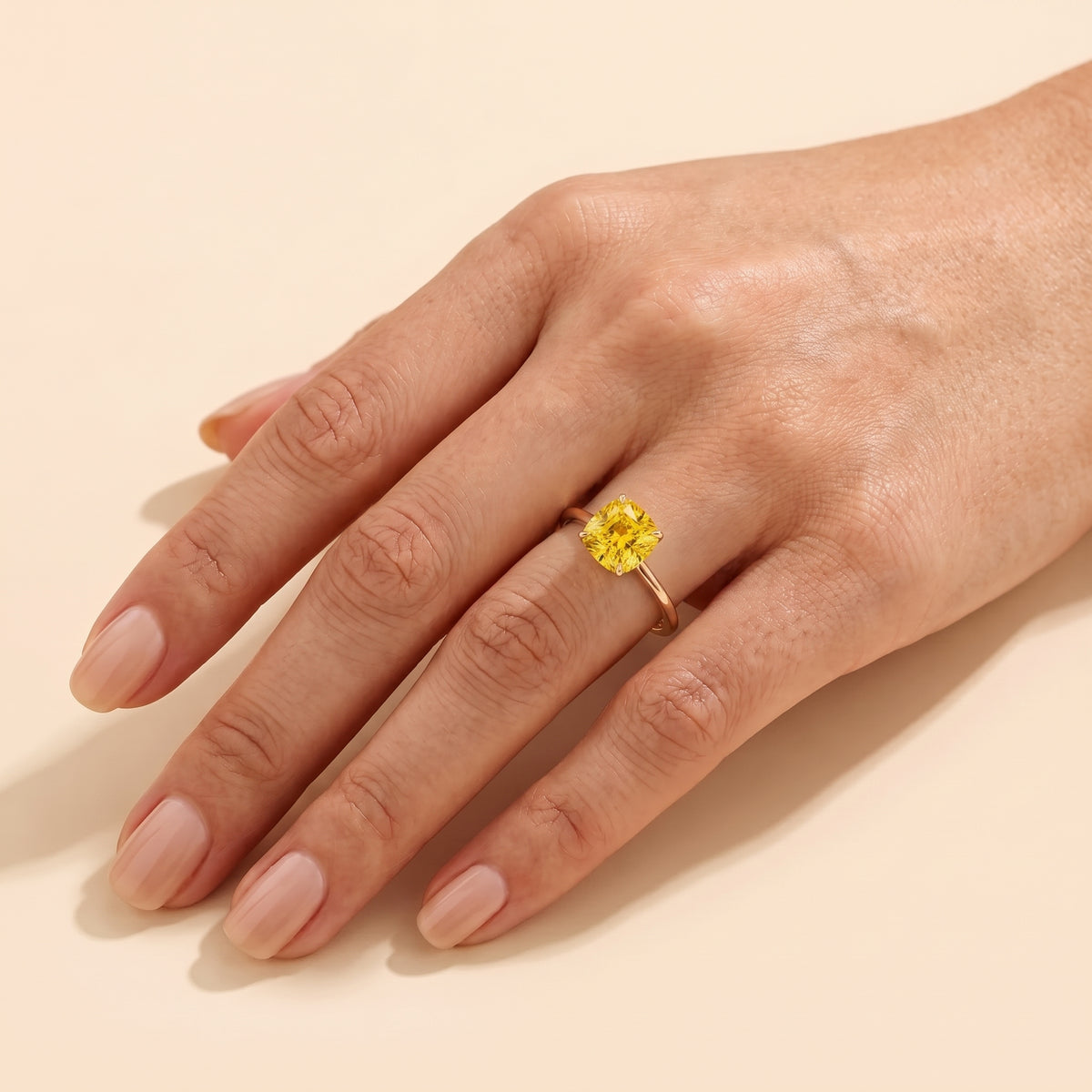 A model is wearing Iris Cushion Shape Yellow Sapphire Cathedral Solitaire