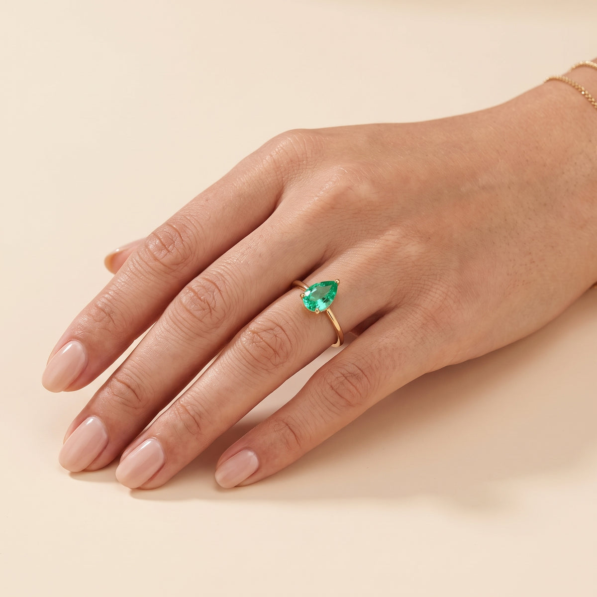 A model is wearing The Pandal Pear Shape Green Sapphire Cathedral Solitaire Ring