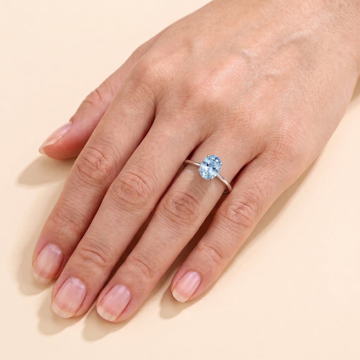 The model is wearing Lyra Oval Shape Aquamarine Cathedral Solitaire Ring in White Gold