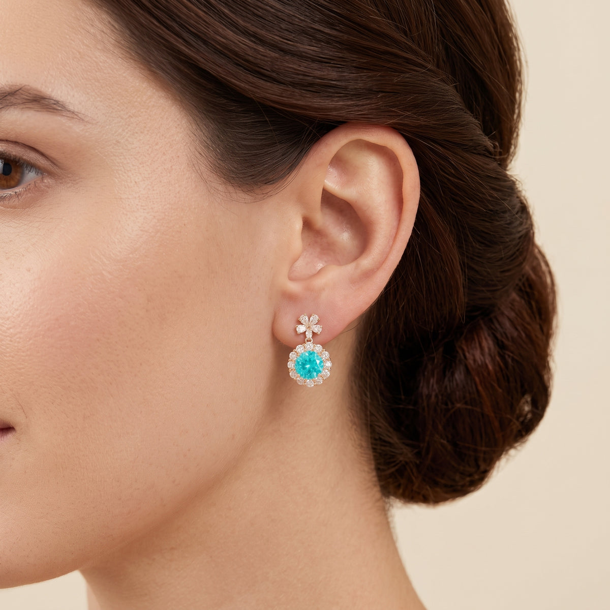 A model is wearing The Antoinette Round Paraiba Tourmaline & Diamond Halo Pendant Earrings with Flower Bail 