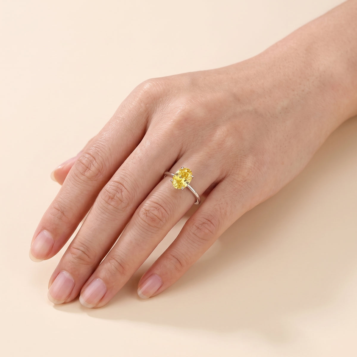 A model is wearing Lyra Oval Shape Yellow Sapphire Cathedral Solitaire Ring in White Gold