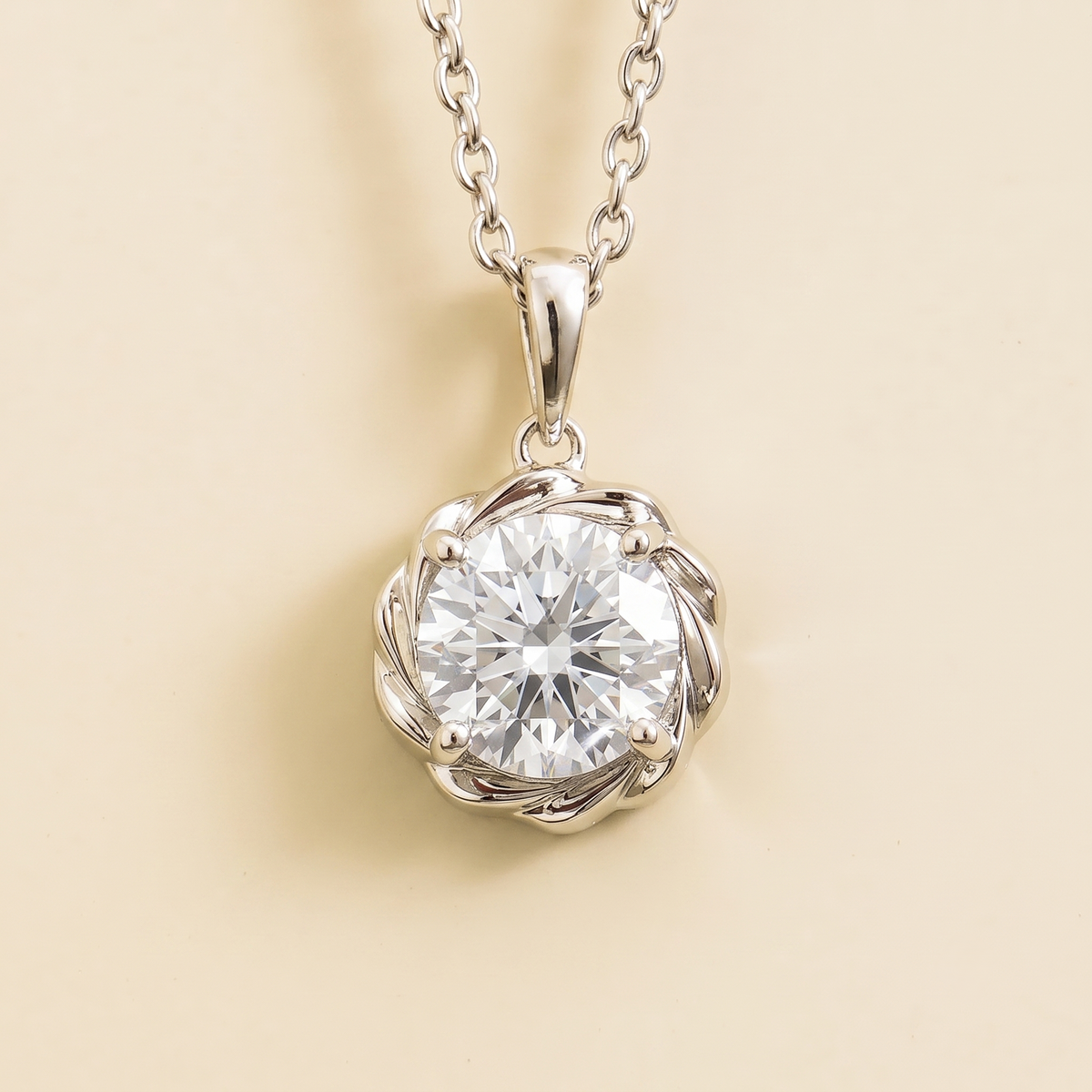 A white gold necklace with a round diamond and detailed halo pendant on a chain.