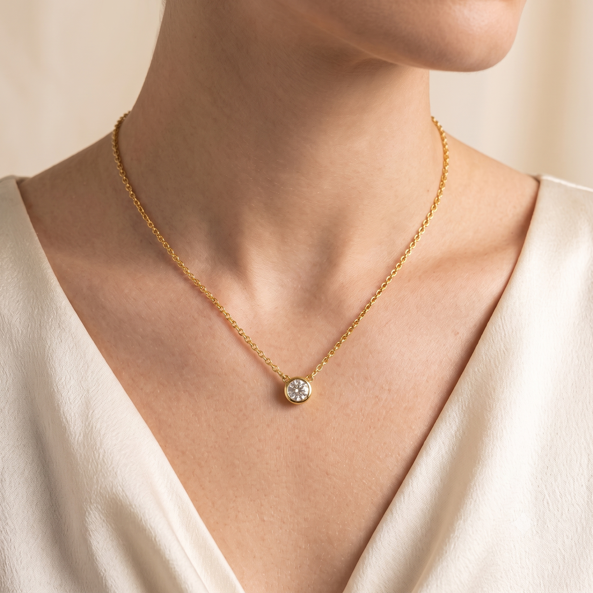 A model is wearing Margo Diamond Round Bezel Set Solitaire Gold Necklace by Juvetti, bespoke jewellery London