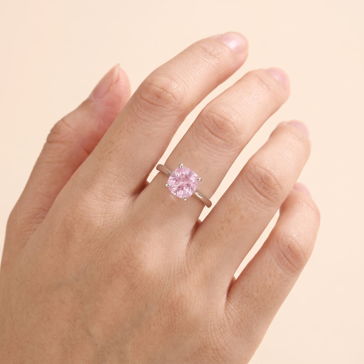 A model is wearing Iris Cushion Shape Pink Sapphire Cathedral Solitaire
