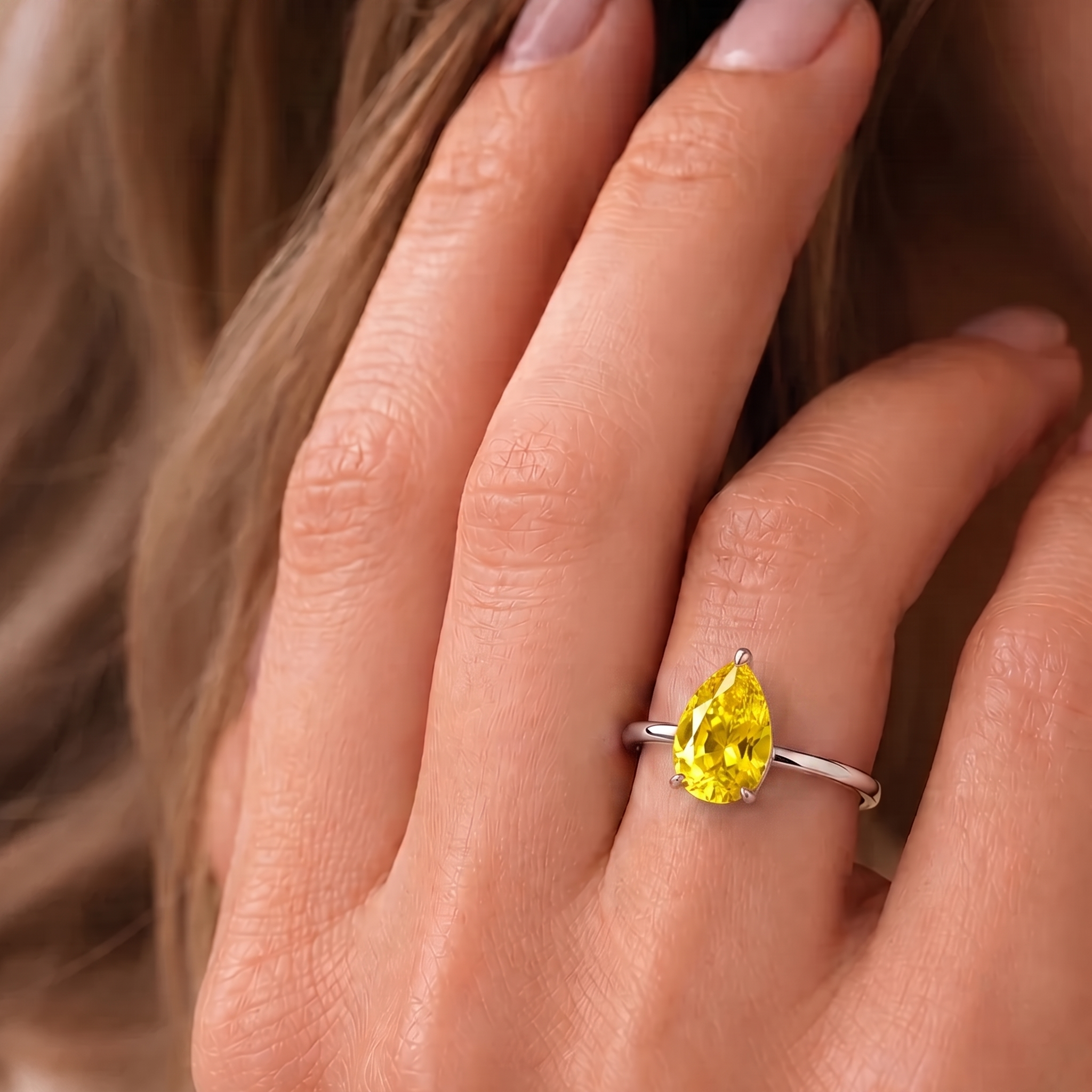 A model is wearing Pandal Pear Shape Yellow Sapphire Cathedral Solitaire Ring in white gold