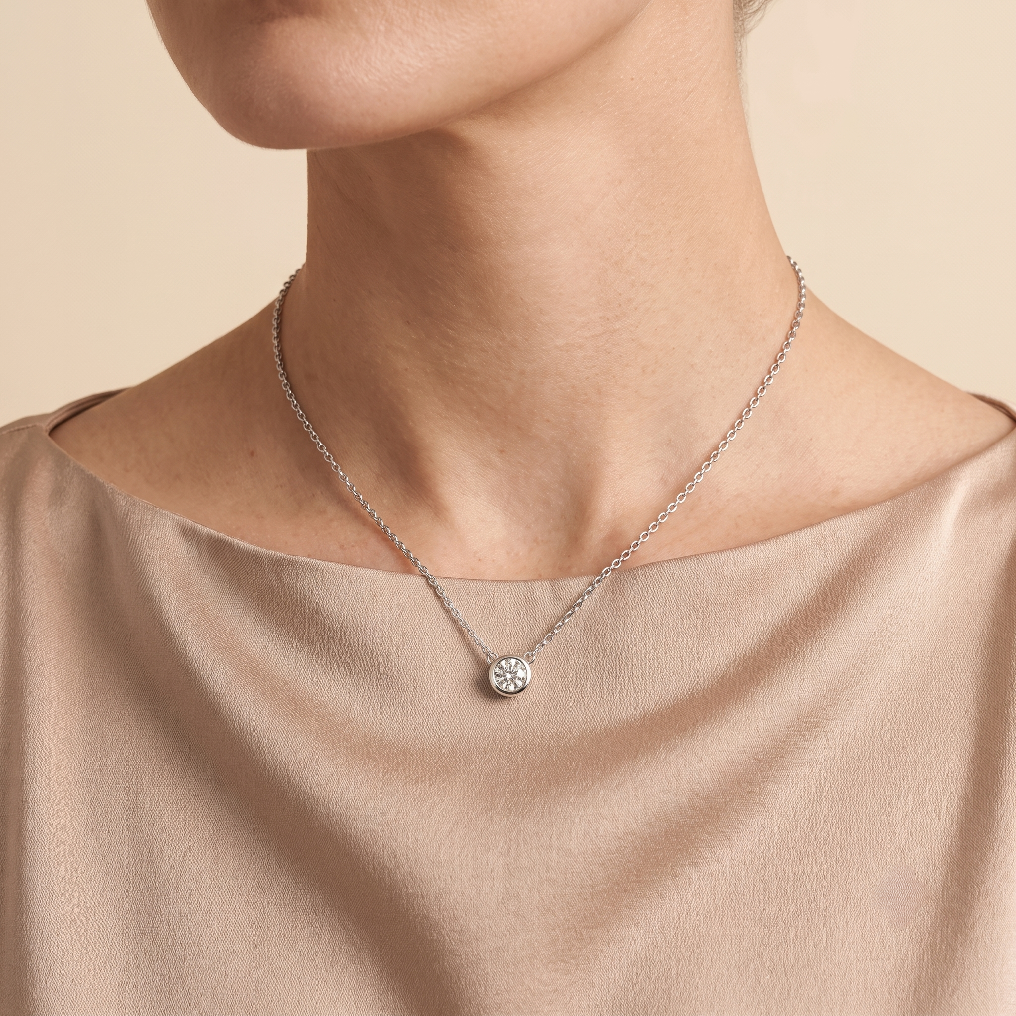 A model is wearing Margo Diamond Round Bezel Set Solitaire White Gold Necklace by Juvetti, bespoke jewellery London