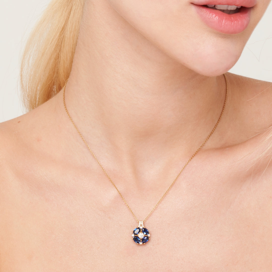 A model wearing Pristi pendant necklace set with lab grown diamond and oval cut blue sapphire