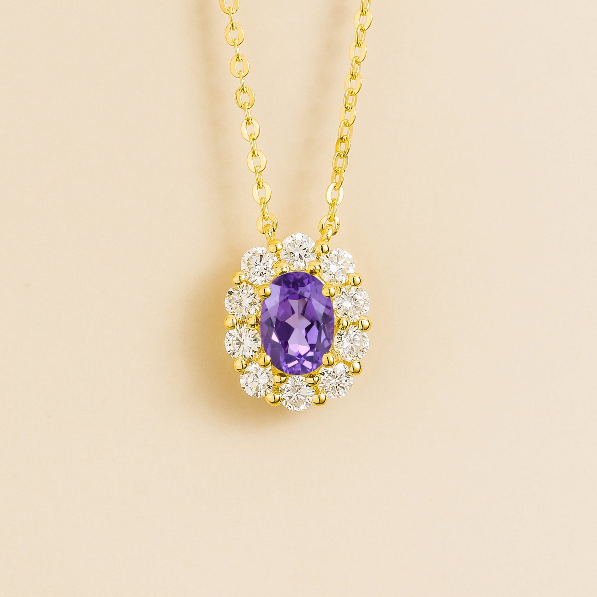 Prill Necklace in Gold set with oval Purple Sapphire and round halo Diamonds. London jewellery store