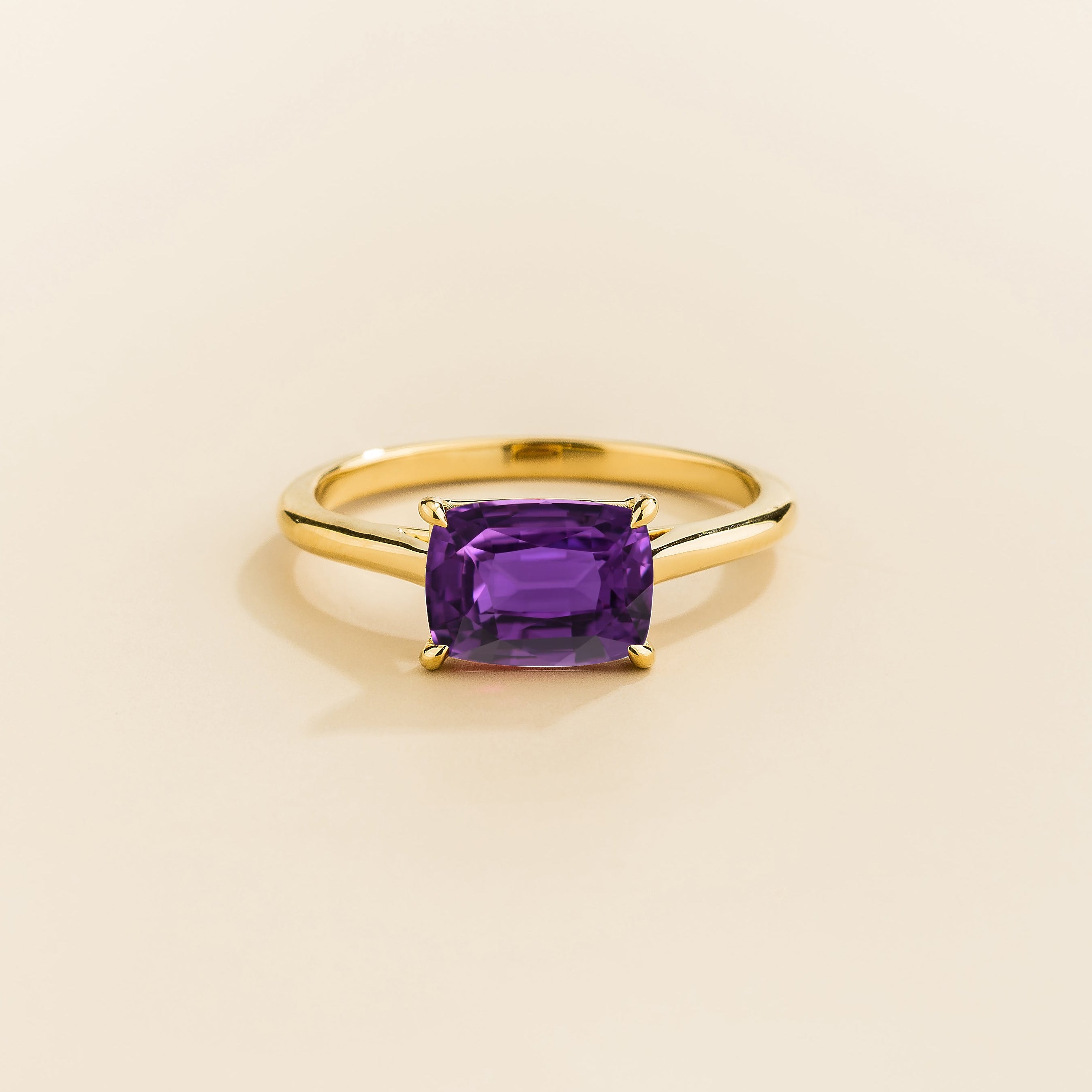Kissen Ring in gold, set with a Purple Sapphire in an east–west setting.