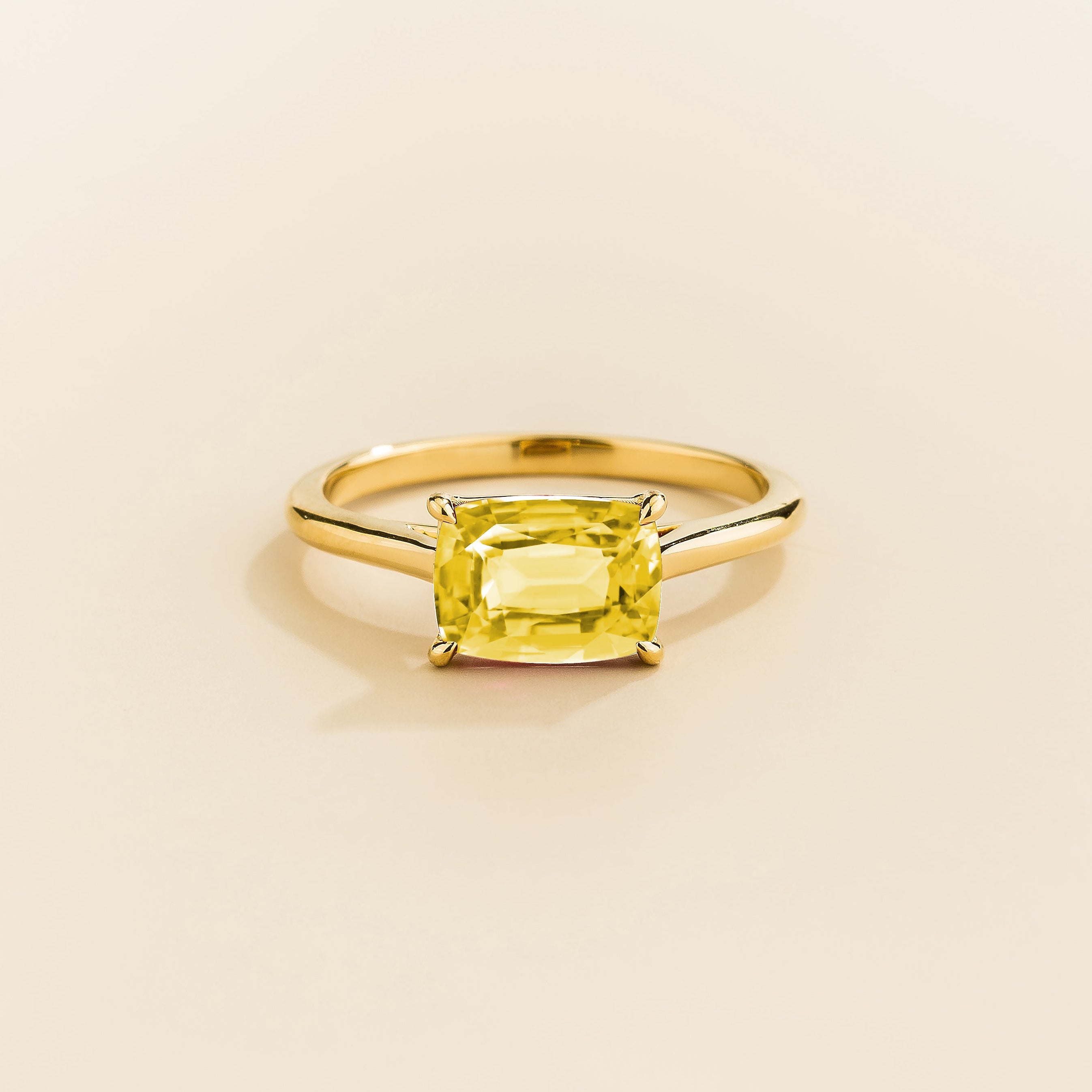 Kissen Ring in gold, set with a Yellow Sapphire in an east–west setting.
