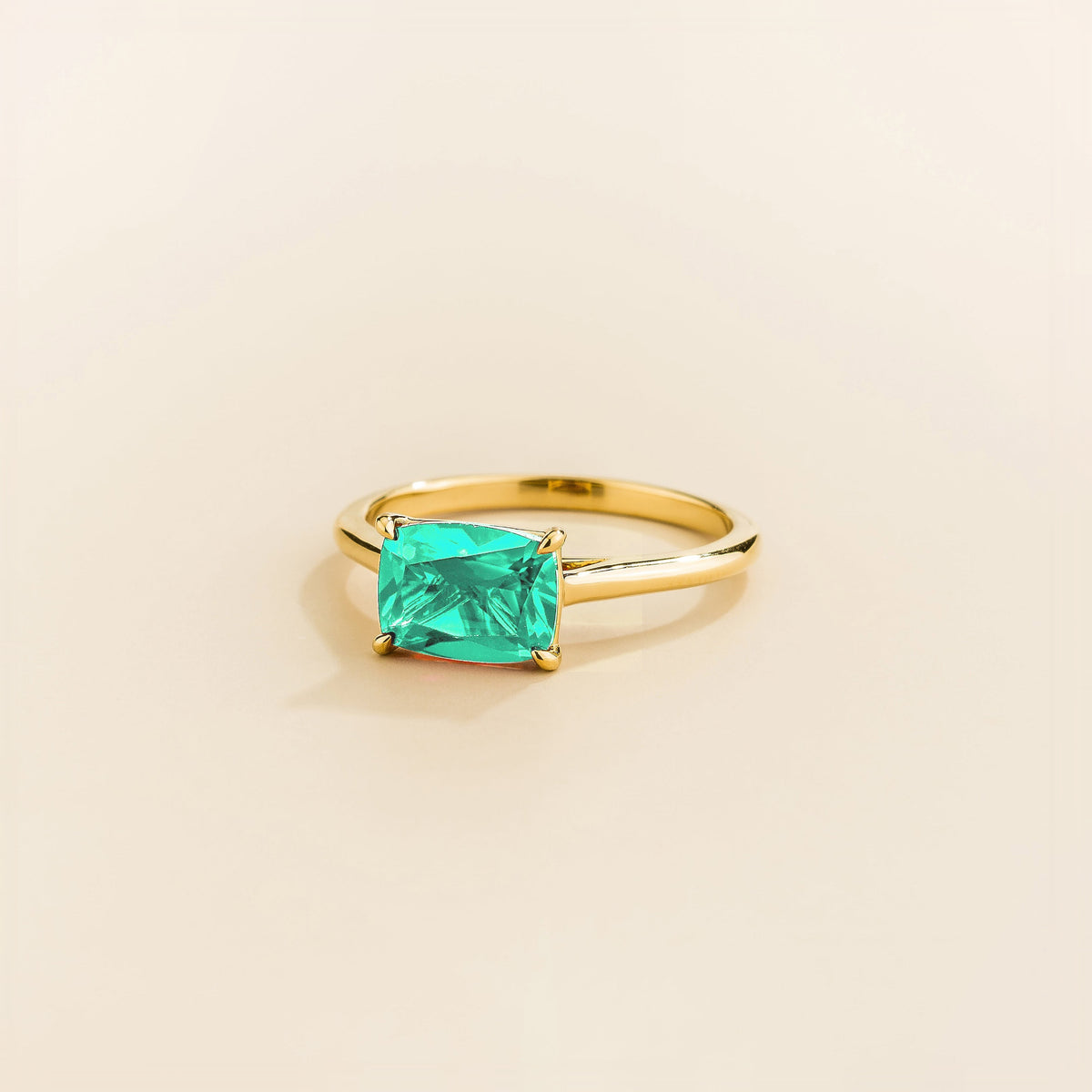 Kissen Ring in gold, set with a Paraiba in an east–west setting.