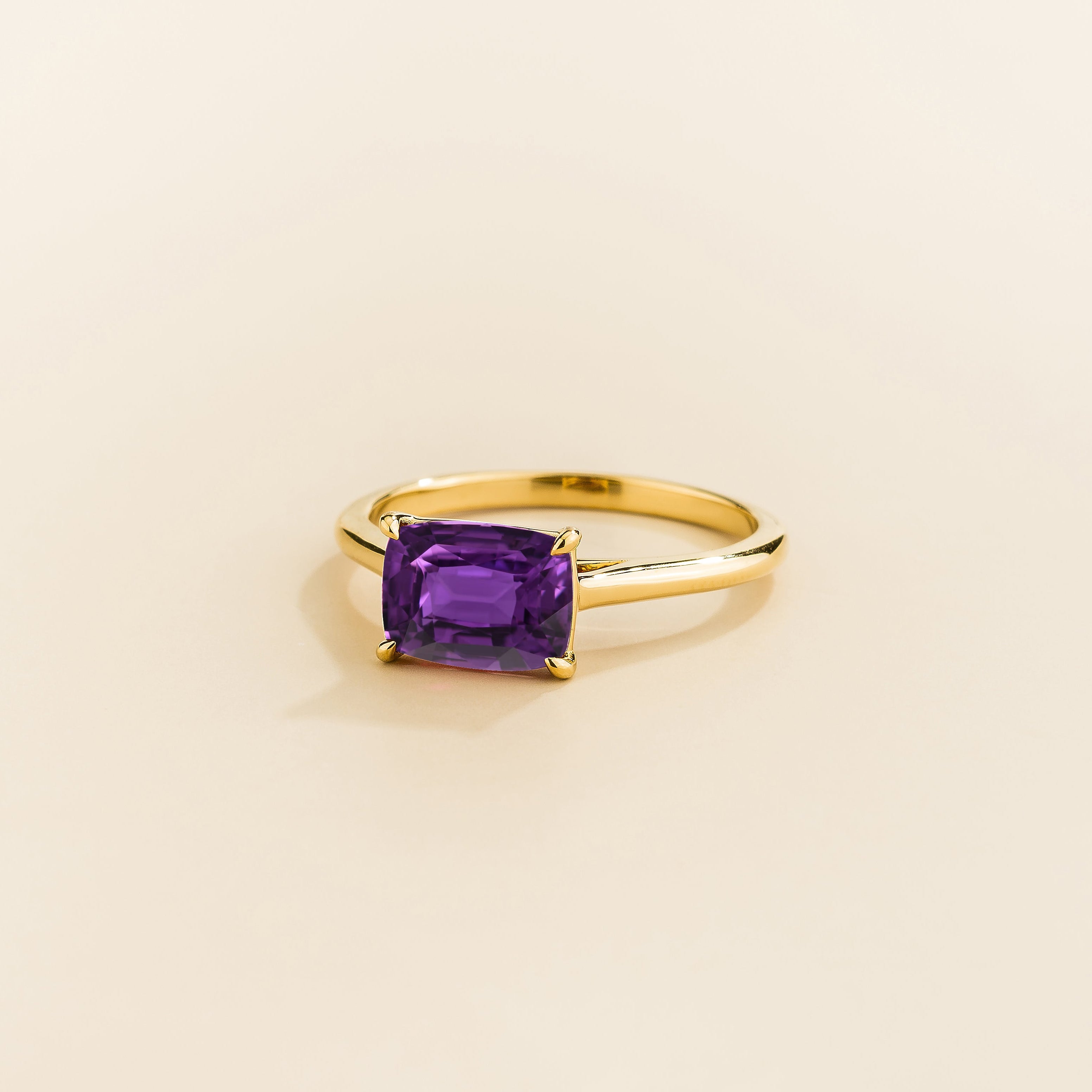 Kissen Ring in gold, set with a Purple Sapphire in an east–west setting.