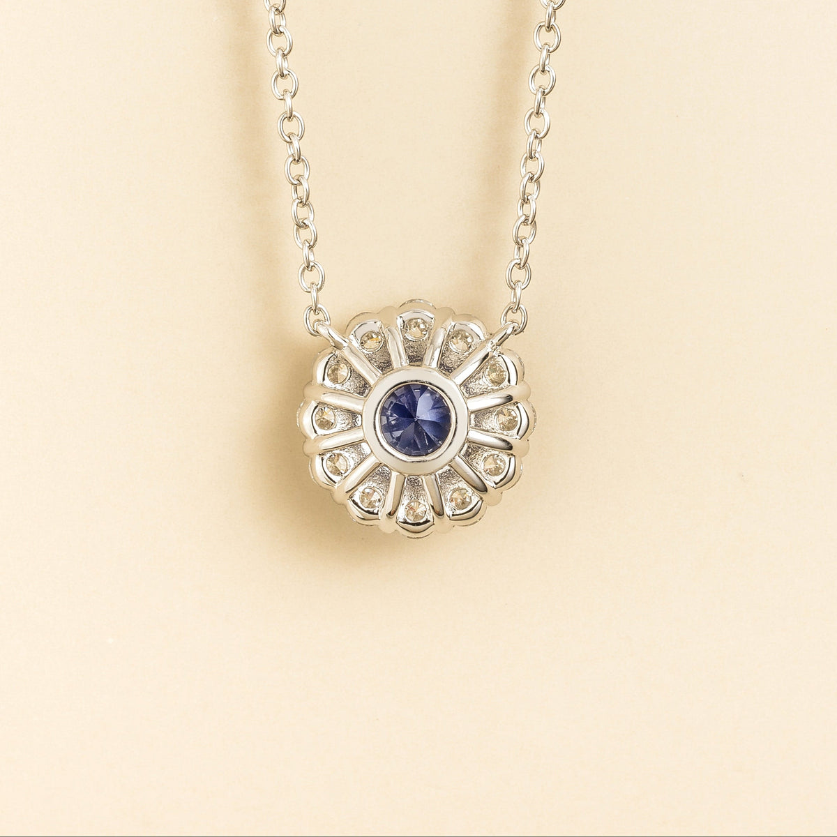 Zoe Blue Sapphire Round & Diamond Halo Necklace In White Gold angled view