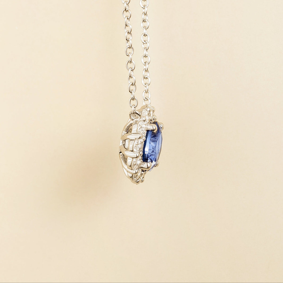 Zoe Blue Sapphire Round & Diamond Halo Necklace In White Gold angled view