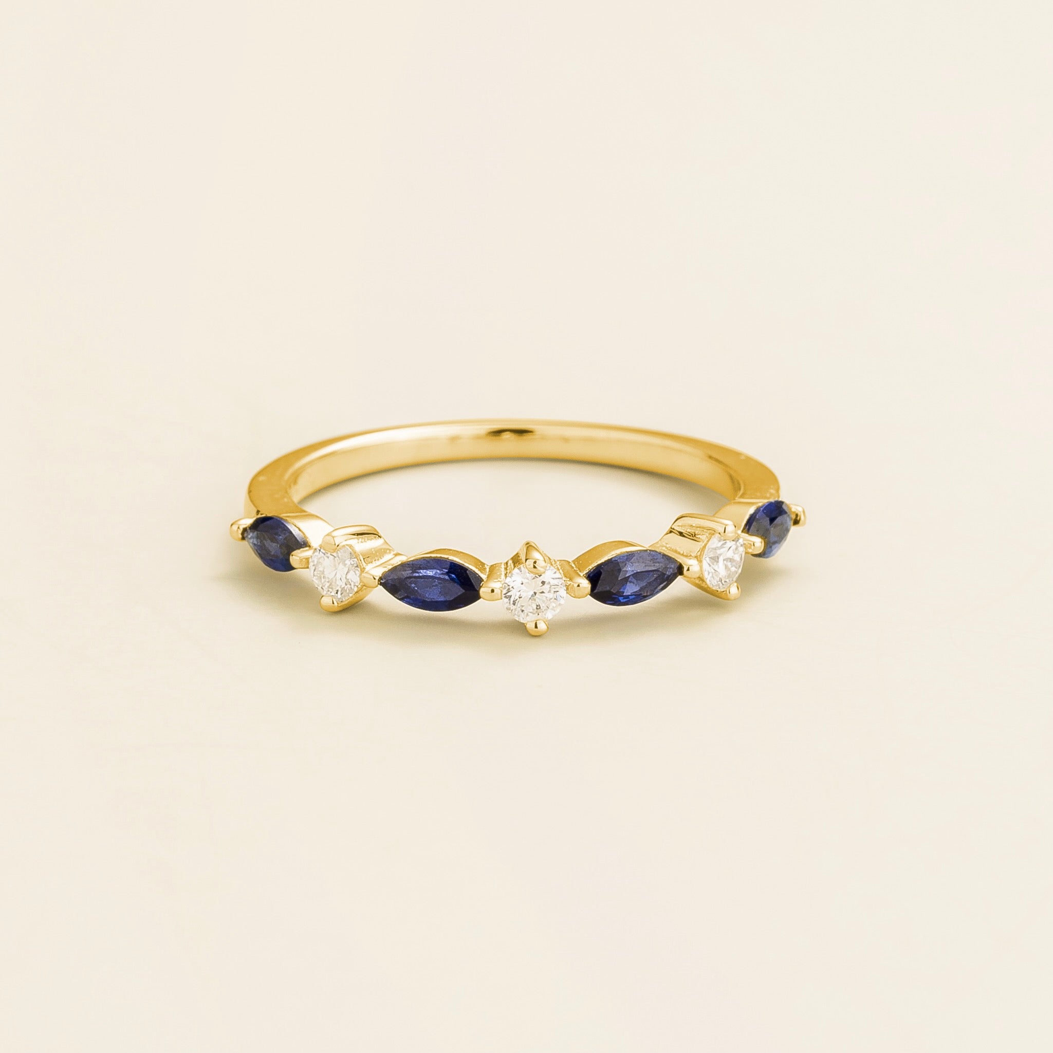 A gold band ring with marquise cut blue sapphires and round diamonds 