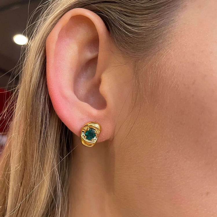 Model wearing Fava Gold Earrings Set With Emerald By Bespoke Jewellery London