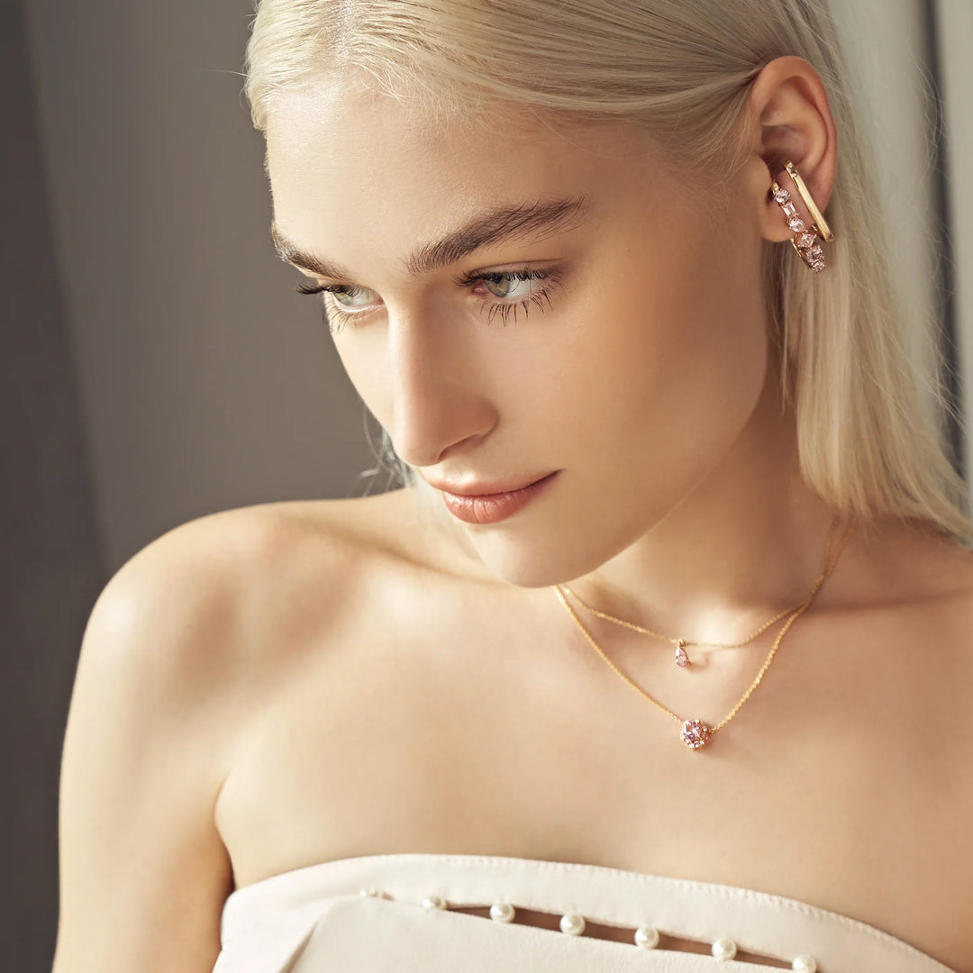 Our model is wearing cuff Serene earrings, pear drop necklace and hexagon Melba earrings set with lab grown diamonds and pink sapphire gem stones.