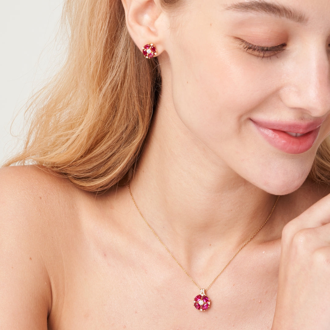 A model is wearing Pristi necklace and earrings set with lab grown diamond and oval cut ruby gem stones.