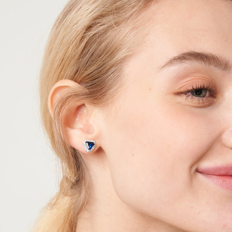 A model wearing Diana earrings set with lab grown diamond and royal blue sapphire gem stones.
